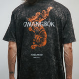 Person wearing a black t-shirt with a tiger graphic and 'GWANGBOK' text on the back.