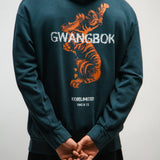 Person wearing a teal hoodie with a Korean tiger graphic and 'GWANGBOK' text on the back.