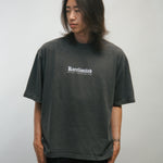 Person wearing a dark gray t-shirt with KORELIMITED text on a plain background