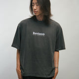 Person wearing a dark gray t-shirt with KORELIMITED text on a plain background
