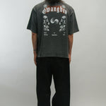 Person wearing a dark gray t-shirt with floral designs and text on the back for Korean Liberation Day, standing against a plain background.