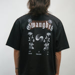 Person wearing a black t-shirt with white graphics and text Gwangbok on the back, standing against a plain background.