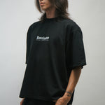 Person wearing a black t-shirt with a KORELIMITED logo on a plain background