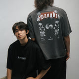 Two people wearing black and gray t-shirts with KORELIMITED and GWANGBOK graphic designs on a plain background