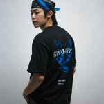 Person wearing a black t-shirt with blue dove bird graphics and white text, standing against a plain background