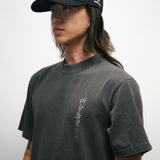 Person wearing a black cap and dark t-shirt with a Korean font logo on a white background