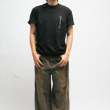 Person wearing a black t-shirt and brown pants on a white background