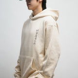 Male person wearing beige hoodie with Korean font in the front